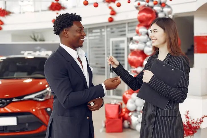 How do car salesman get paid - Image of a car saleswoman handing over car keys.